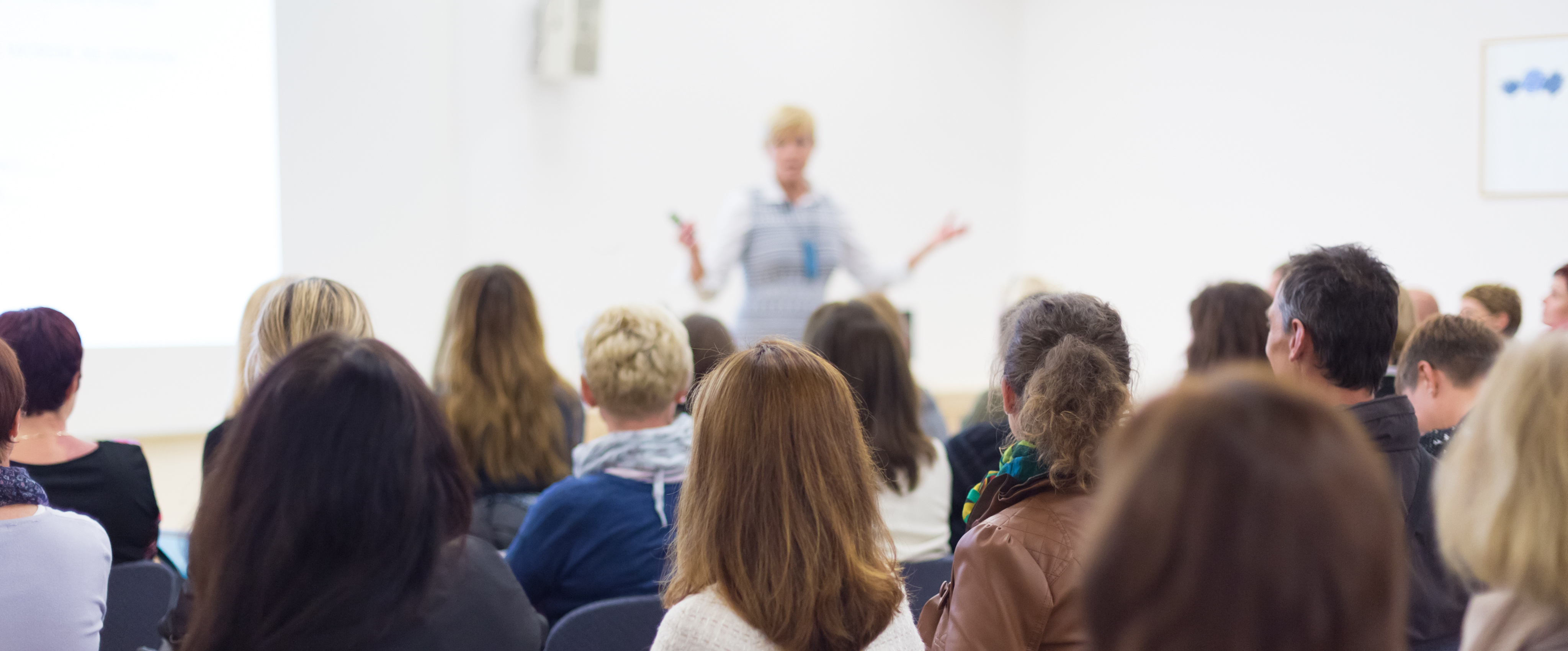 Audience in the lecture hall. Speaker Giving a Talk at Business Meeting. Audience in the conference hall. Business and Entrepreneurship. Panoramic composition suitable for banners.